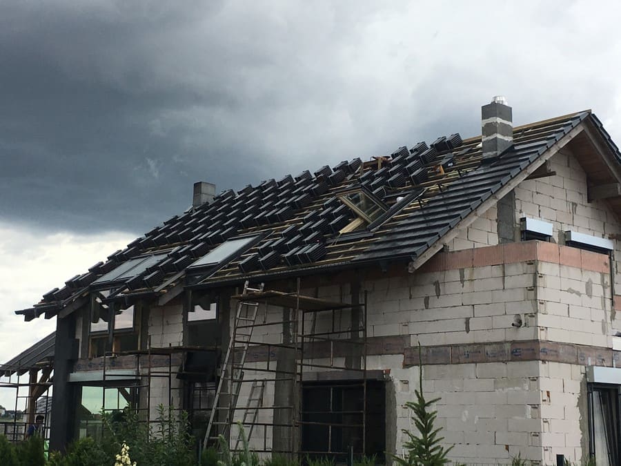układanie dachówek na dachu